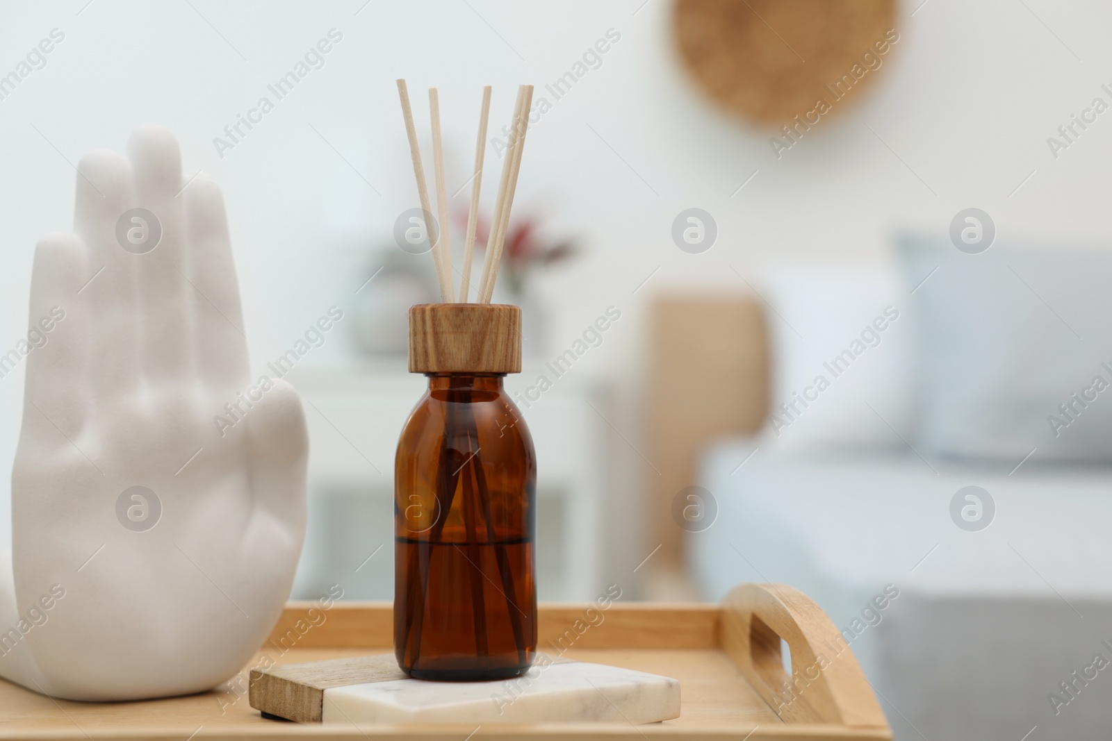 Photo of Aromatic reed air freshener and decor on wooden tray indoors. Space for text