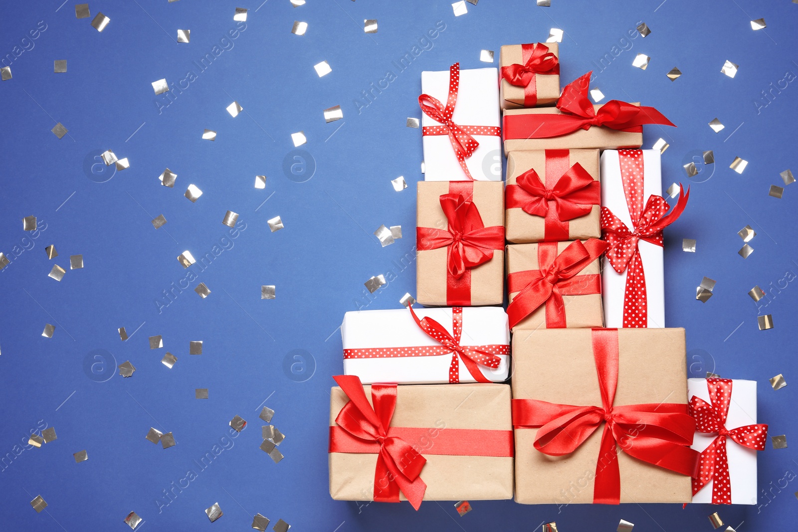 Photo of Christmas tree made with different gift boxes on blue background, flat lay. Space for text