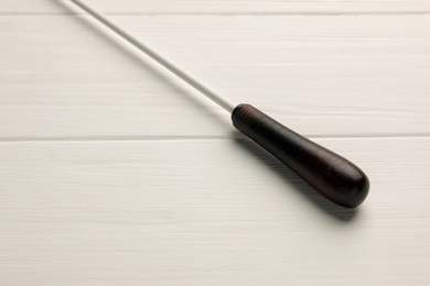 Photo of Conductor's baton on white wooden table, closeup