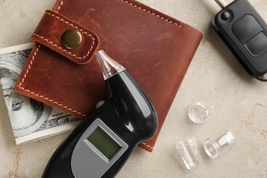 Photo of Flat lay composition with modern breathalyzer on light grey stone table