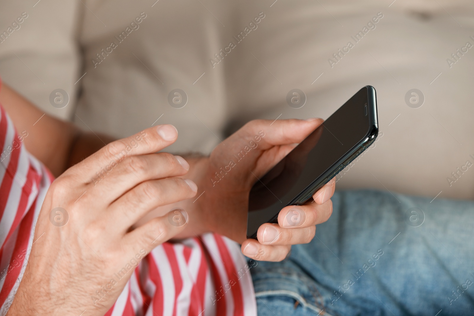 Photo of Man using smartphone at home, closeup view