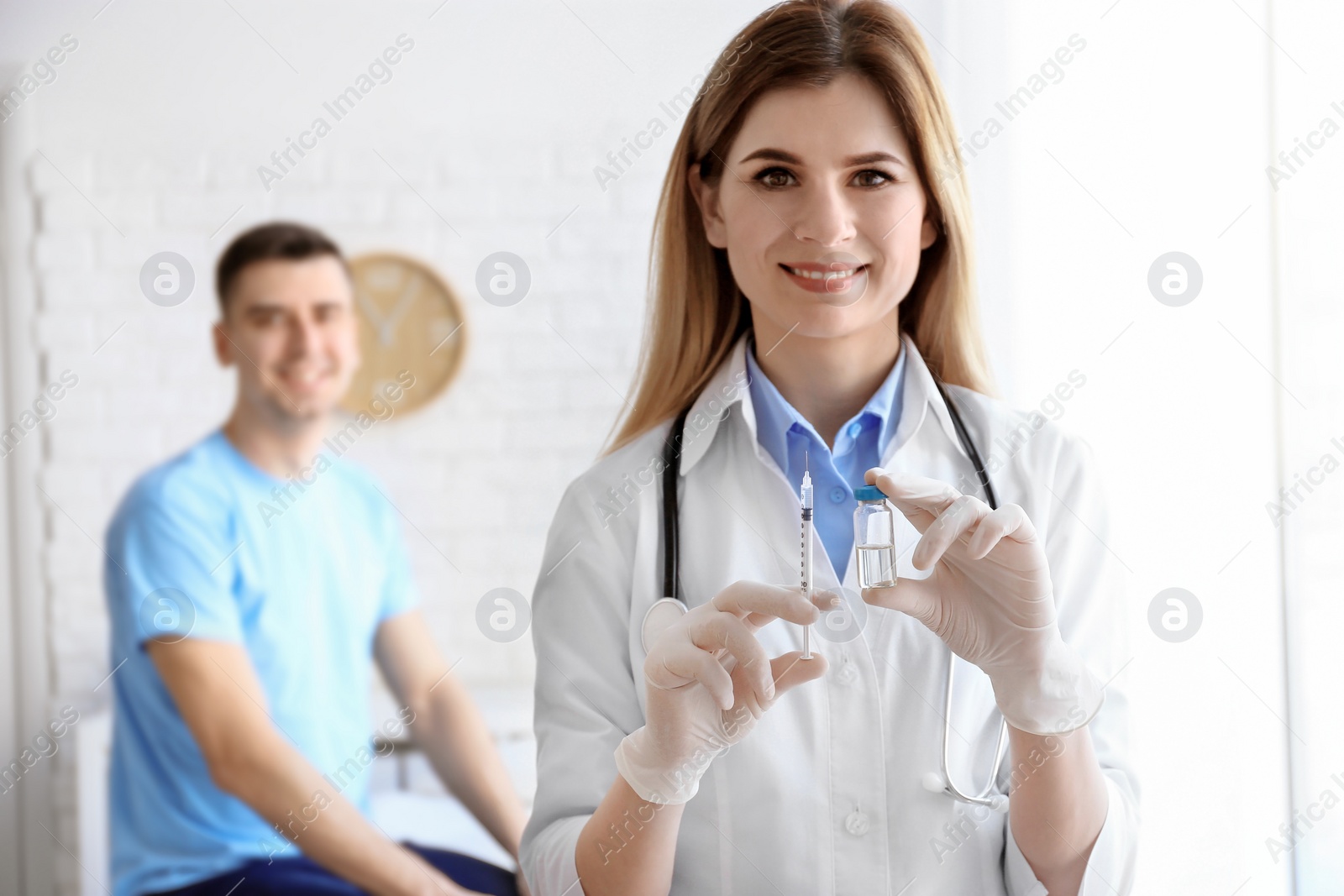 Photo of Doctor holding ampule with vaccine and syringe for patient in clinic