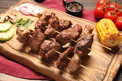 Delicious shish kebabs with vegetables on table