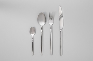 Stylish silver cutlery set on gray background, flat lay