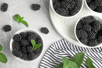 Photo of Flat lay composition of tasty blackberries on grey marble table