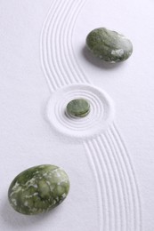 Photo of Zen concept. Stones and pattern on white sand