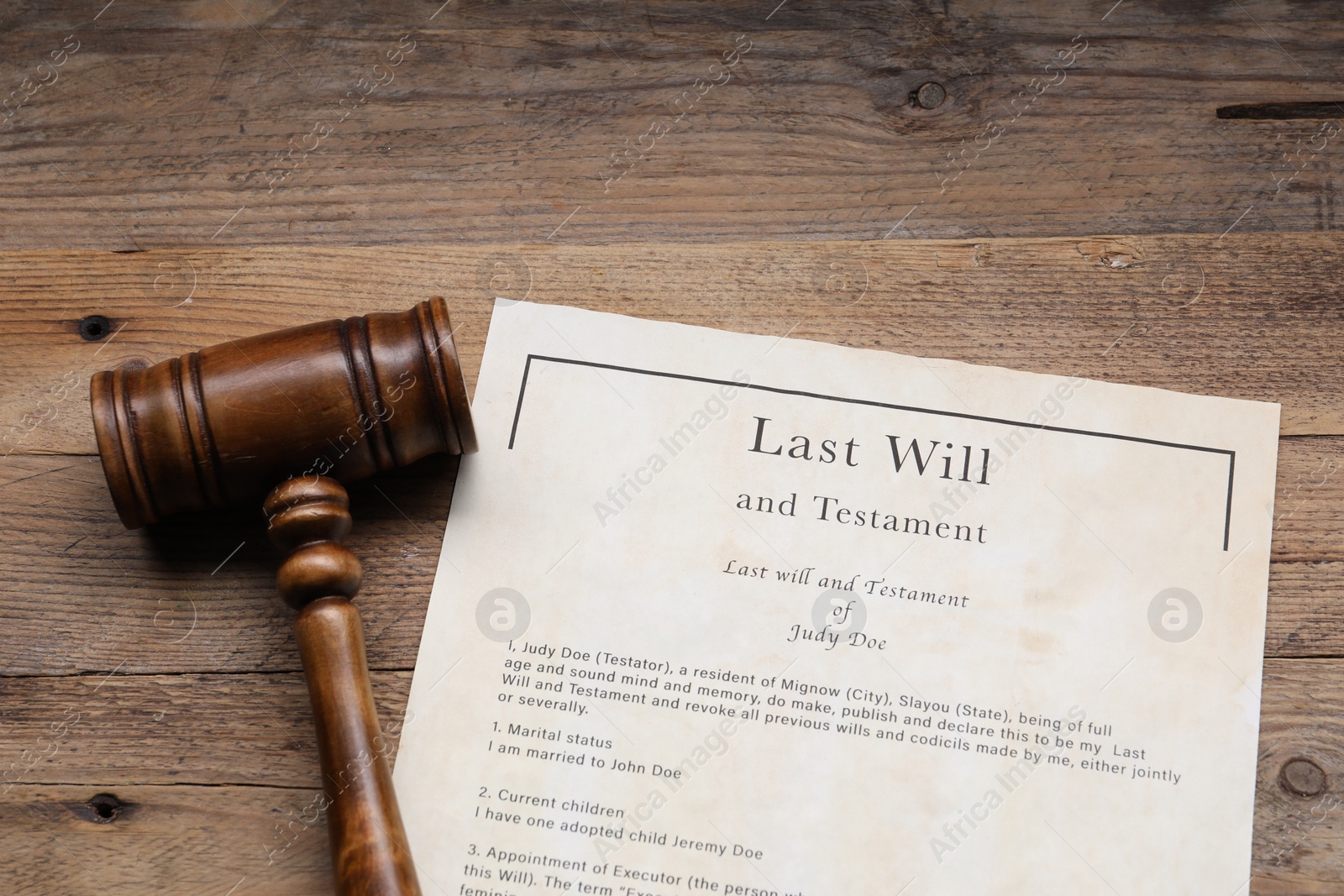 Photo of Last Will and Testament with gavel on wooden table, above view
