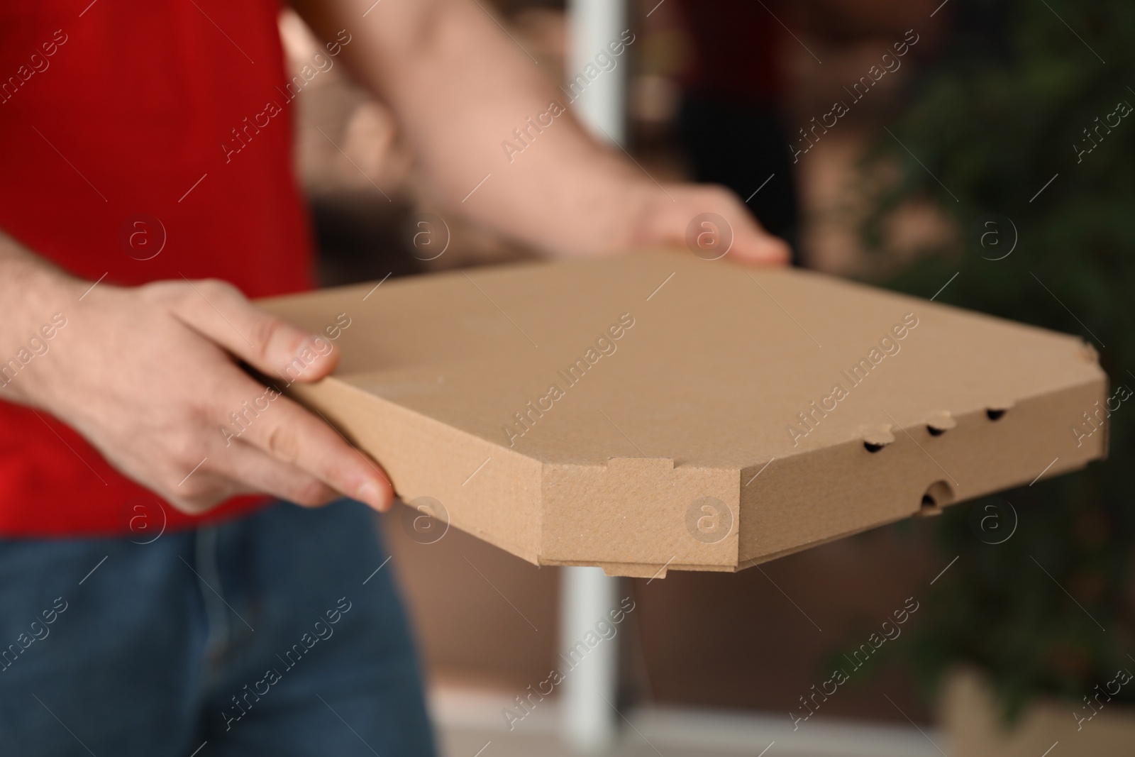 Photo of Courier with pizza box on blurred background, closeup. Space for text