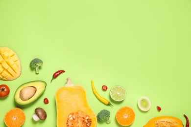 Photo of Flat lay composition with fresh organic fruits and vegetables on light green background. Space for text