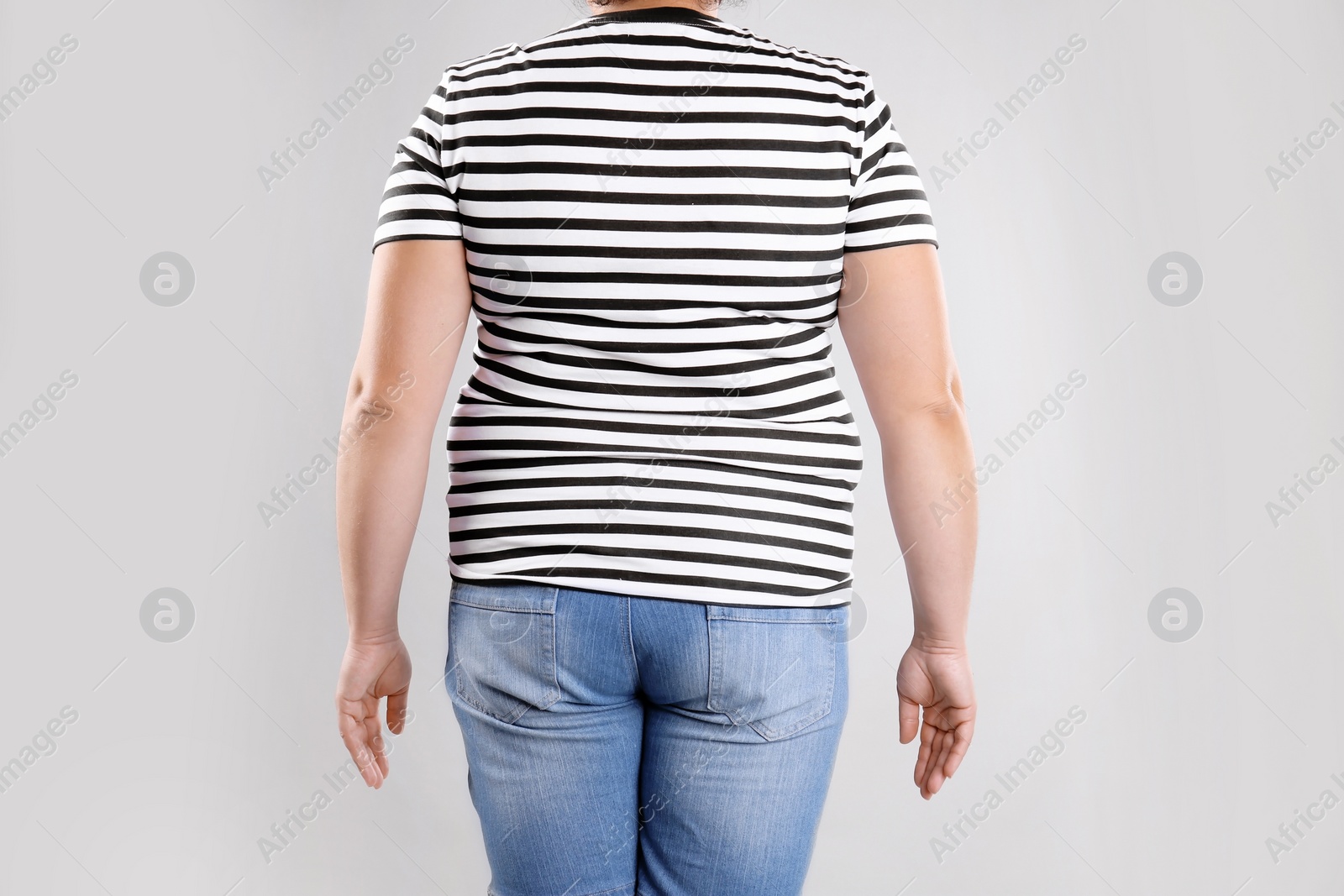 Photo of Fat woman on grey background, closeup. Weight loss