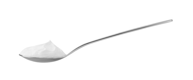 Photo of One silver spoon with sour cream isolated on white