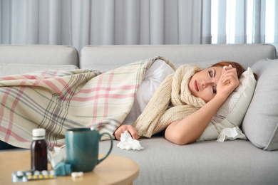 Photo of Sick woman lying on sofa at home. Influenza virus