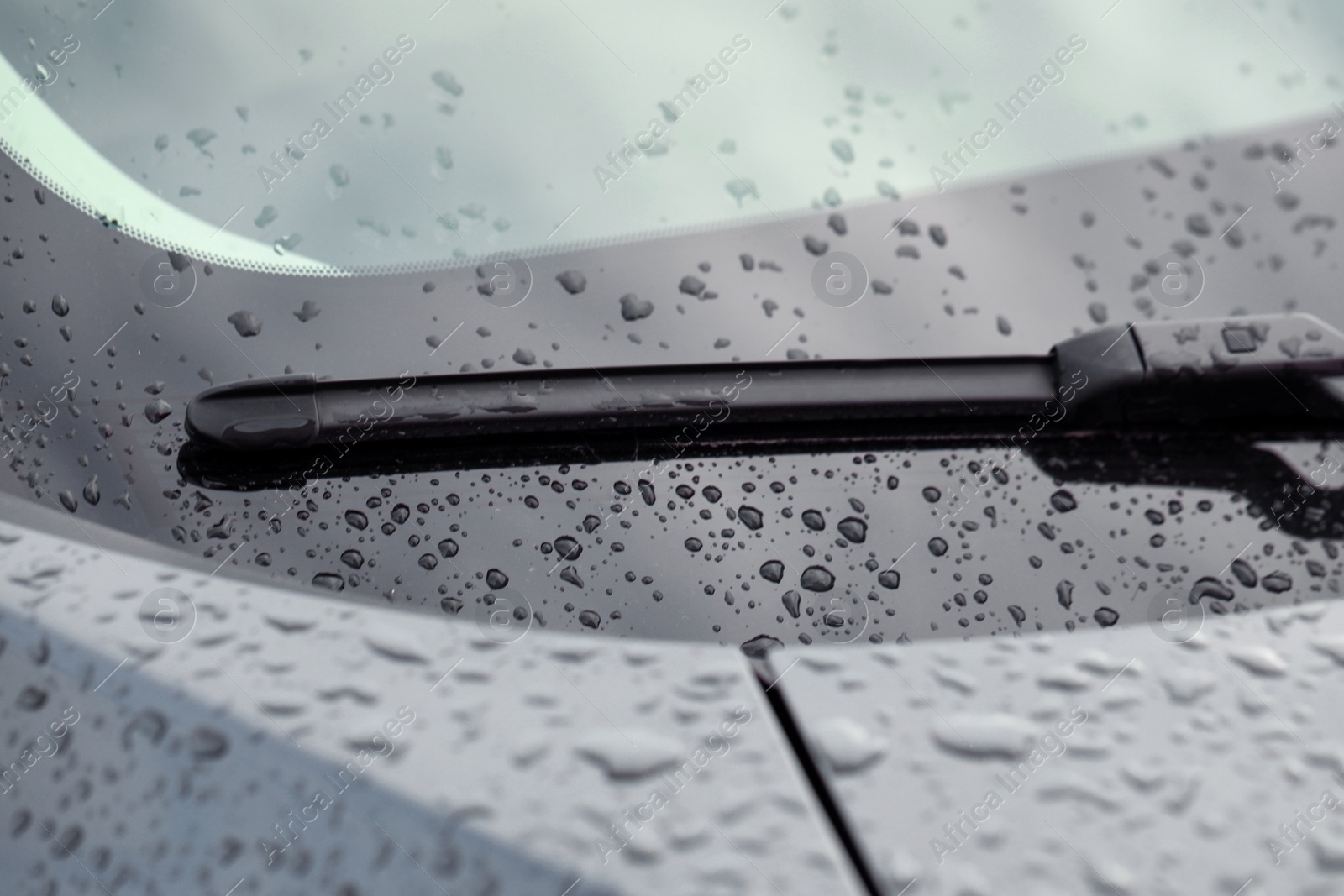 Photo of Car wiper and water drops on windshield glass, closeup
