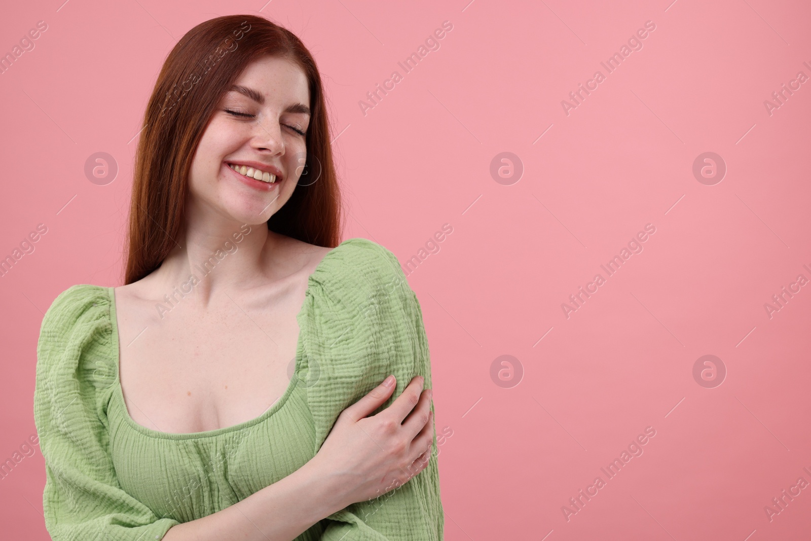 Photo of Portrait of smiling woman with freckles on pink background. Space for text