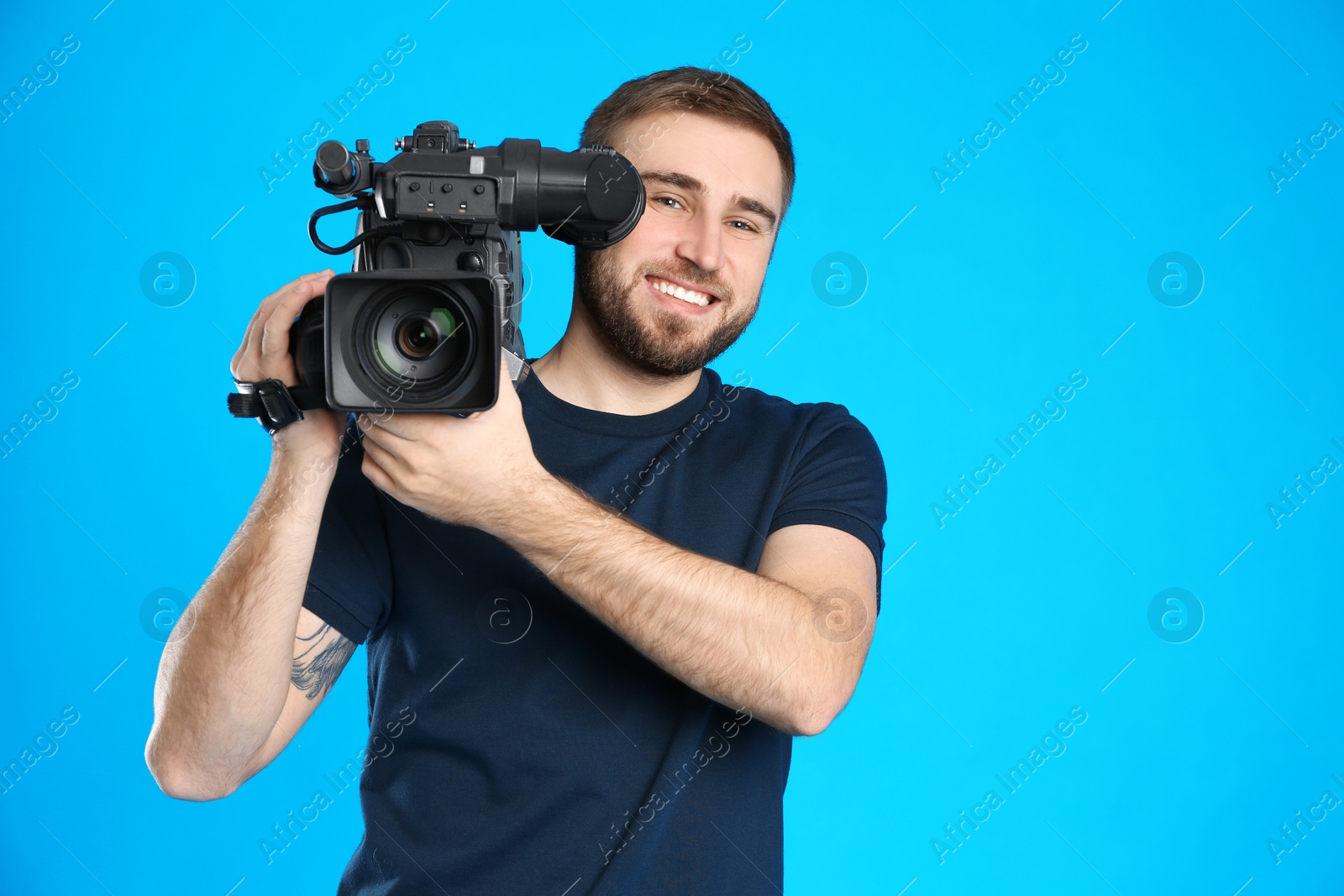 Photo of Operator with professional video camera on blue background