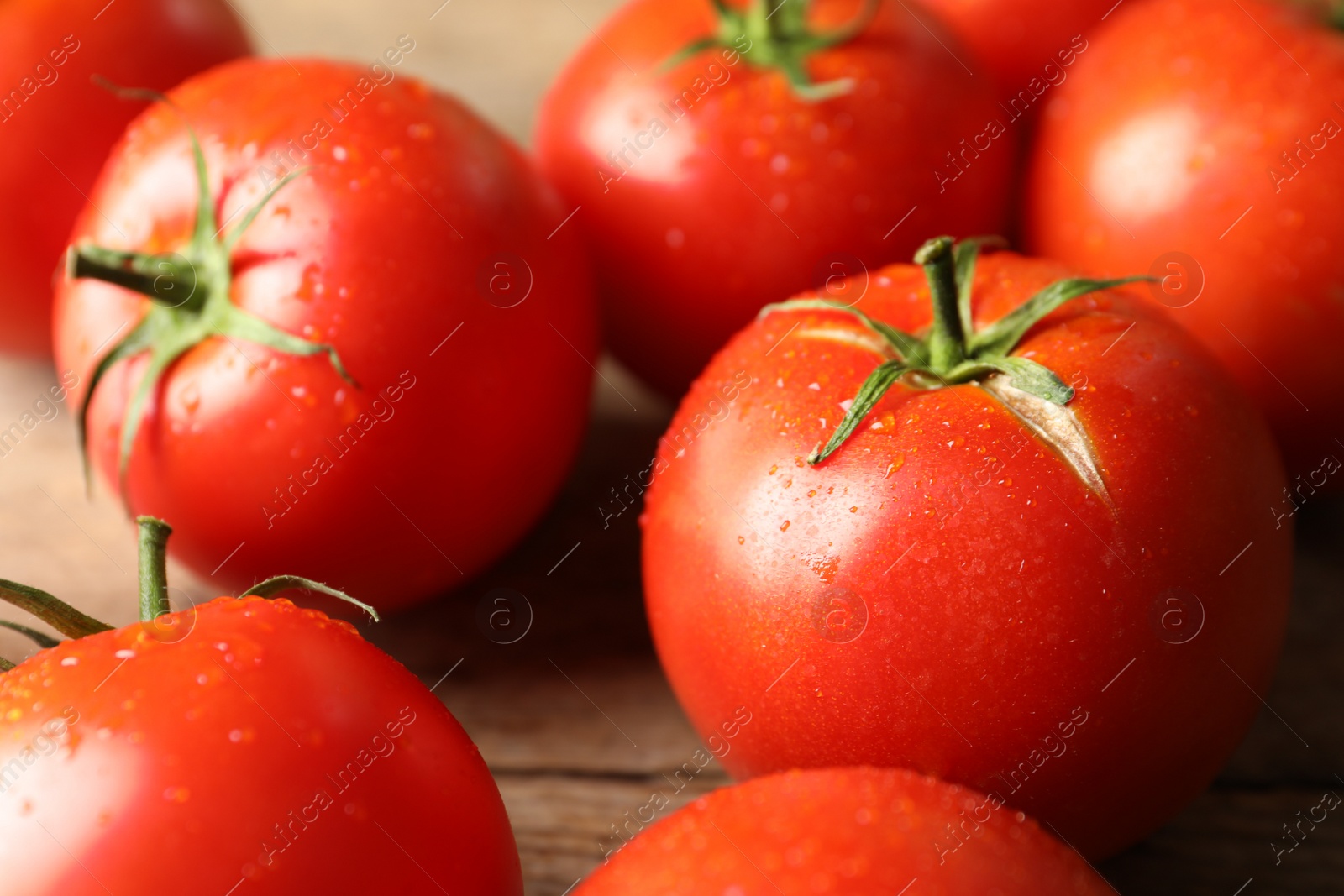 Photo of Fresh ripe tomatoes on wooden table, closeup