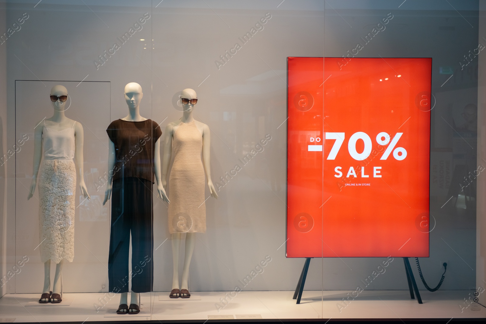 Photo of Siedlce, Poland - July 26, 2022: Sale sign on red stand in showcase at shopping mall. Seasonal discount offer