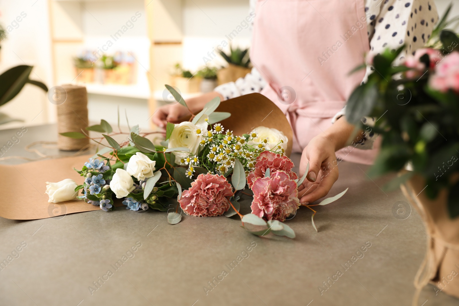 Photo of Florist making bouquet with fresh flowers at table, closeup