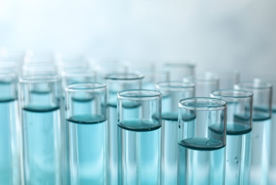 Many test tubes with light blue liquid, closeup