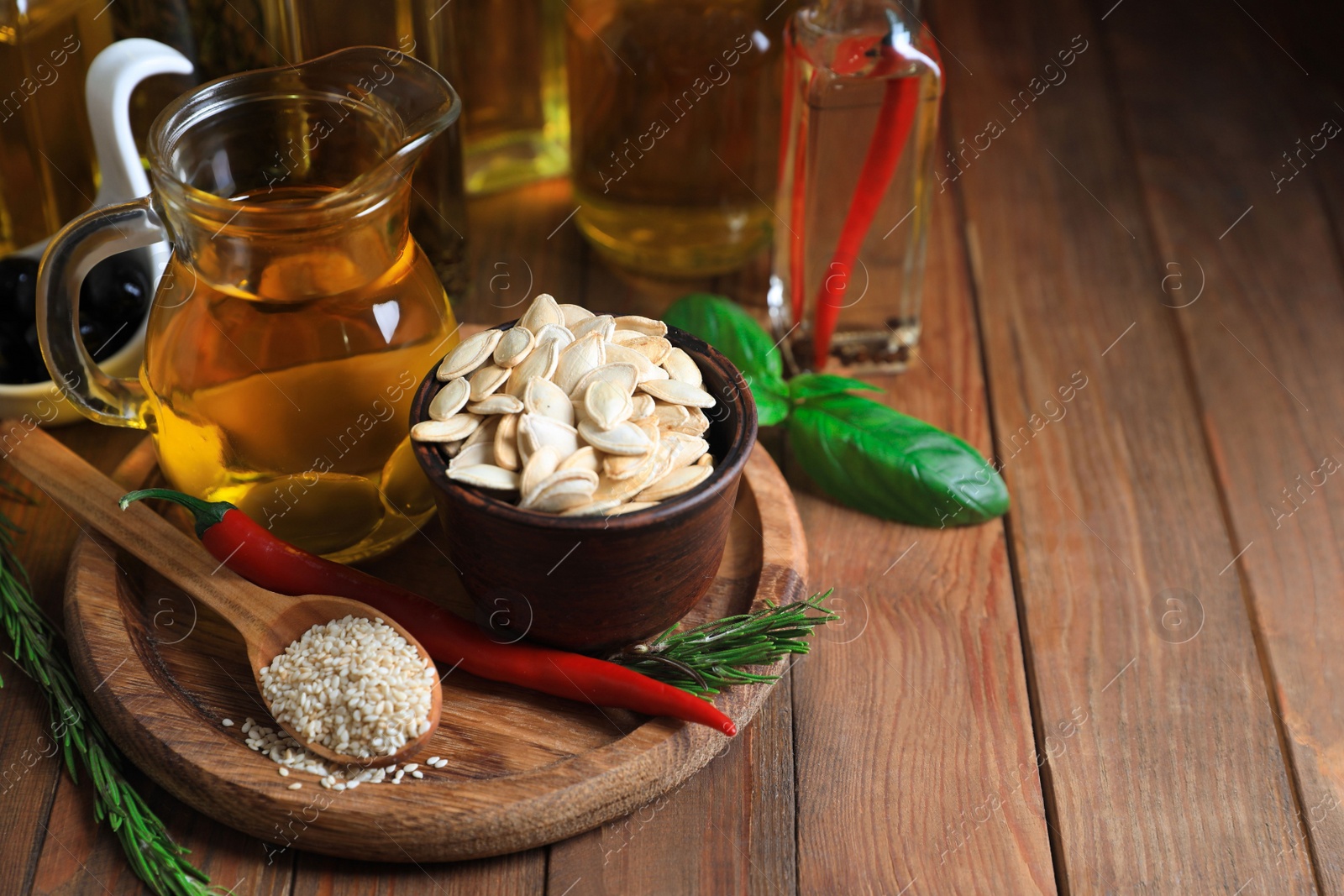 Photo of Different cooking oils and ingredients on wooden table, space for text