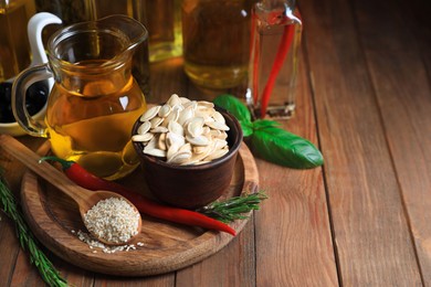 Photo of Different cooking oils and ingredients on wooden table, space for text