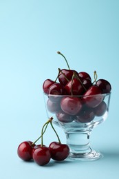 Fresh ripe cherries on light blue background