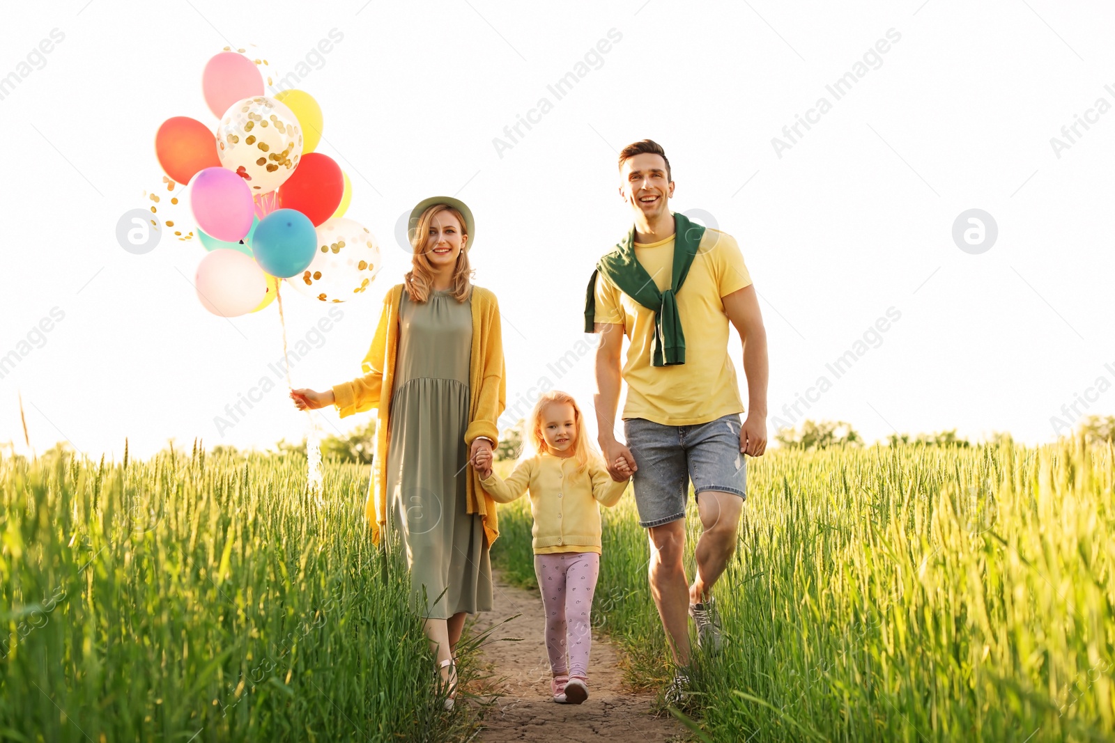 Photo of Happy family with colorful balloons outdoors on sunny day