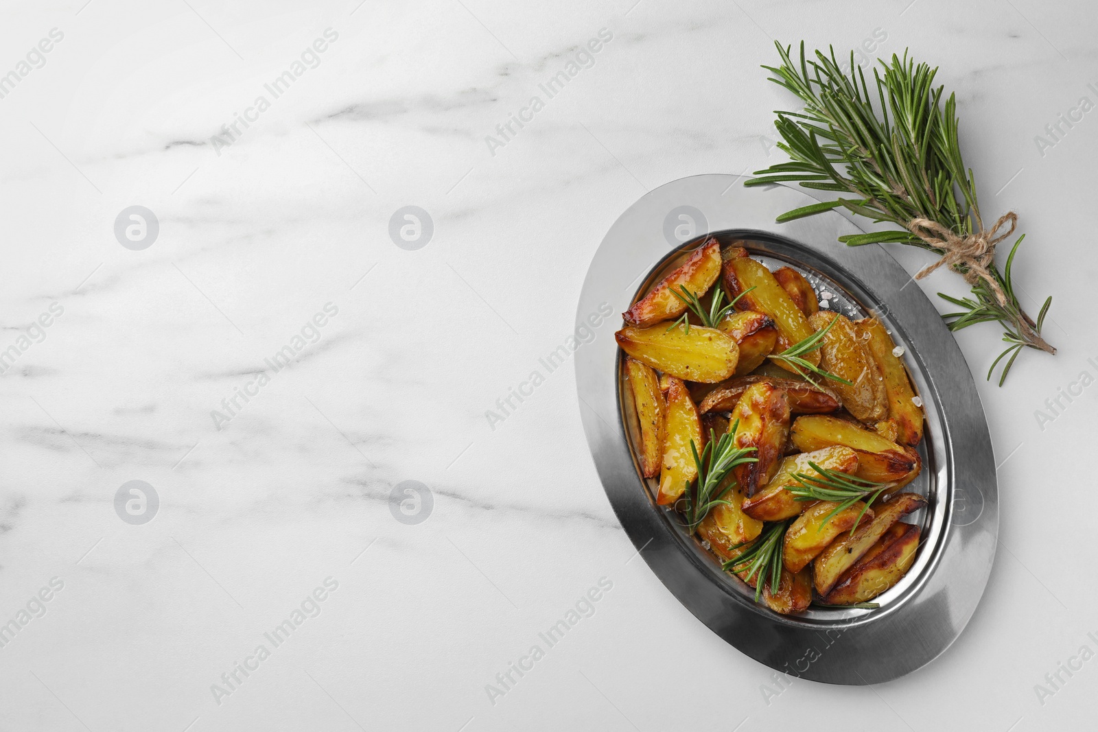 Photo of Plate with baked potato near bunch of aromatic rosemary on white marble table, flat lay. Space for text