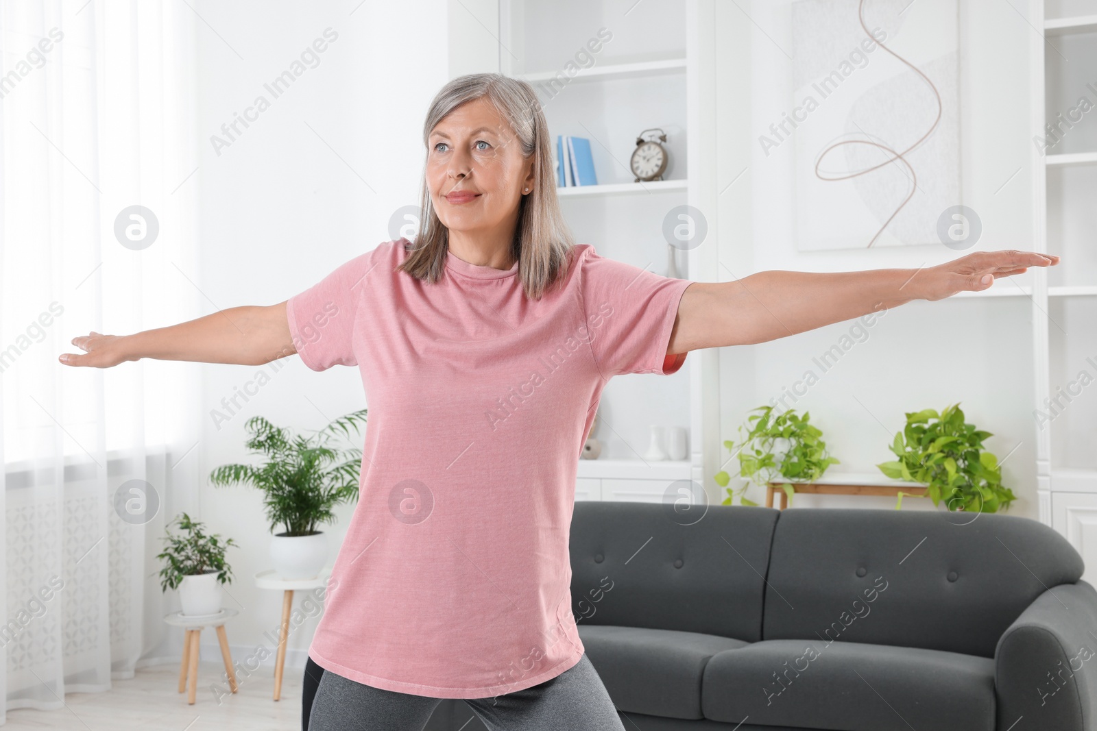 Photo of Senior woman in sportswear doing exercises at home