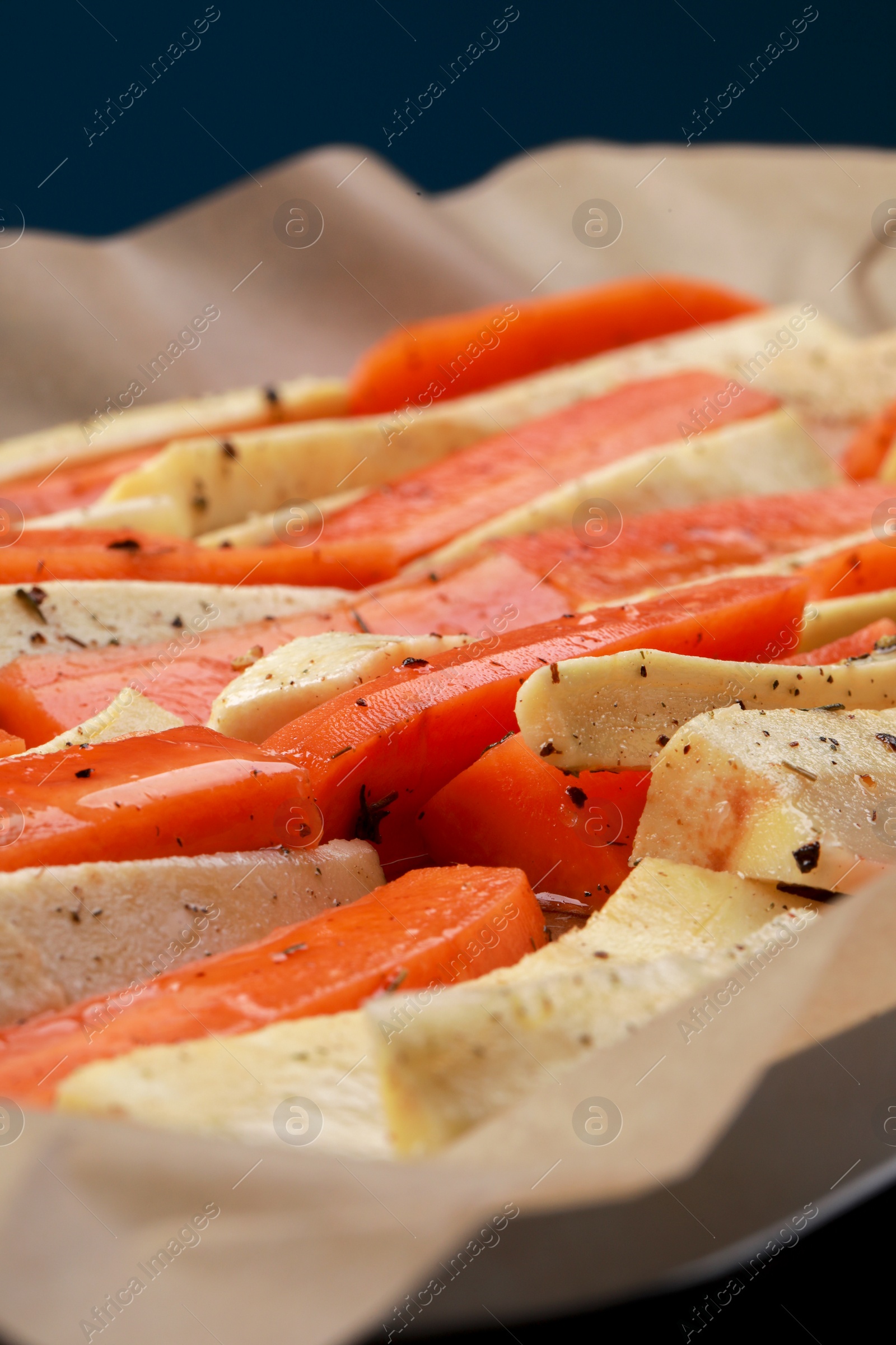Photo of Slices of parsnip and carrot on baking tray, closeup