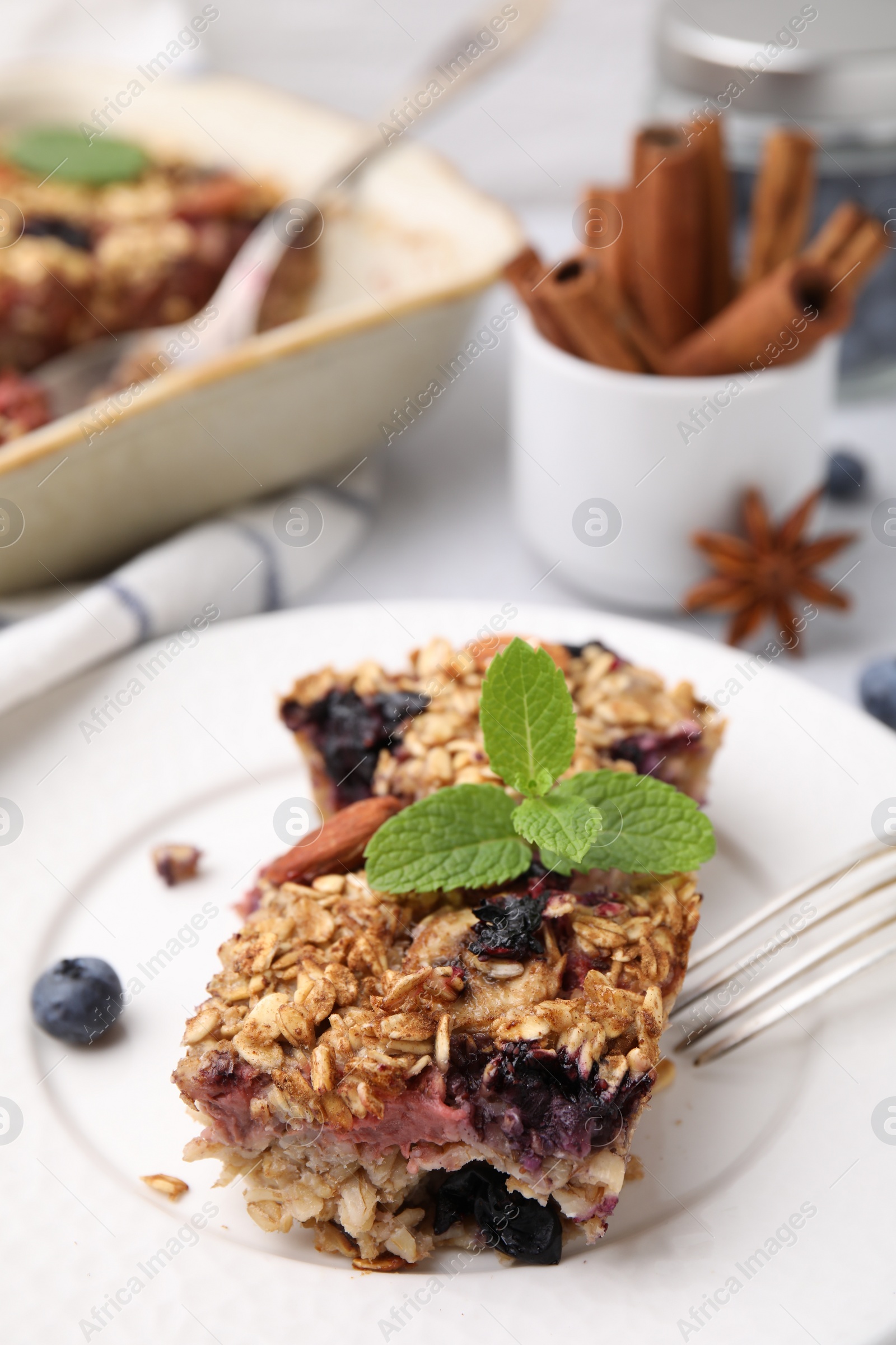 Photo of Tasty baked oatmeal with berries on table, closeup
