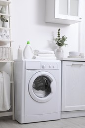 Kitchen interior with washing machine and stylish furniture