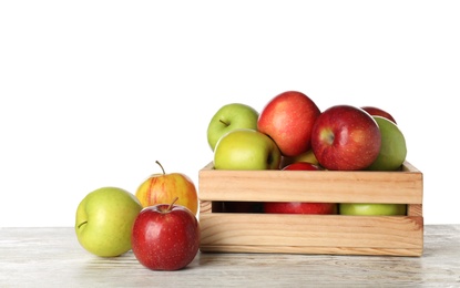 Photo of Wooden crate full of fresh juicy apples on table against white background