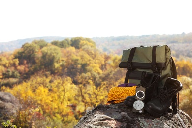 Set of camping equipment on rock outdoors. Space for text