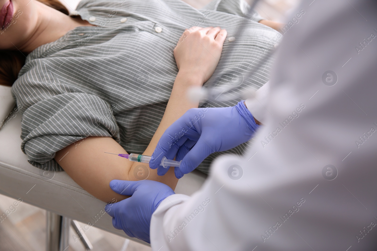 Photo of Doctor giving injection to pregnant woman in hospital, closeup. Vaccination concept