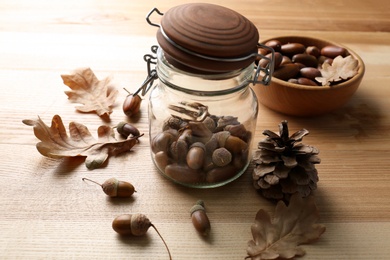 Photo of Acorns, oak leaves and pine cone on wooden table