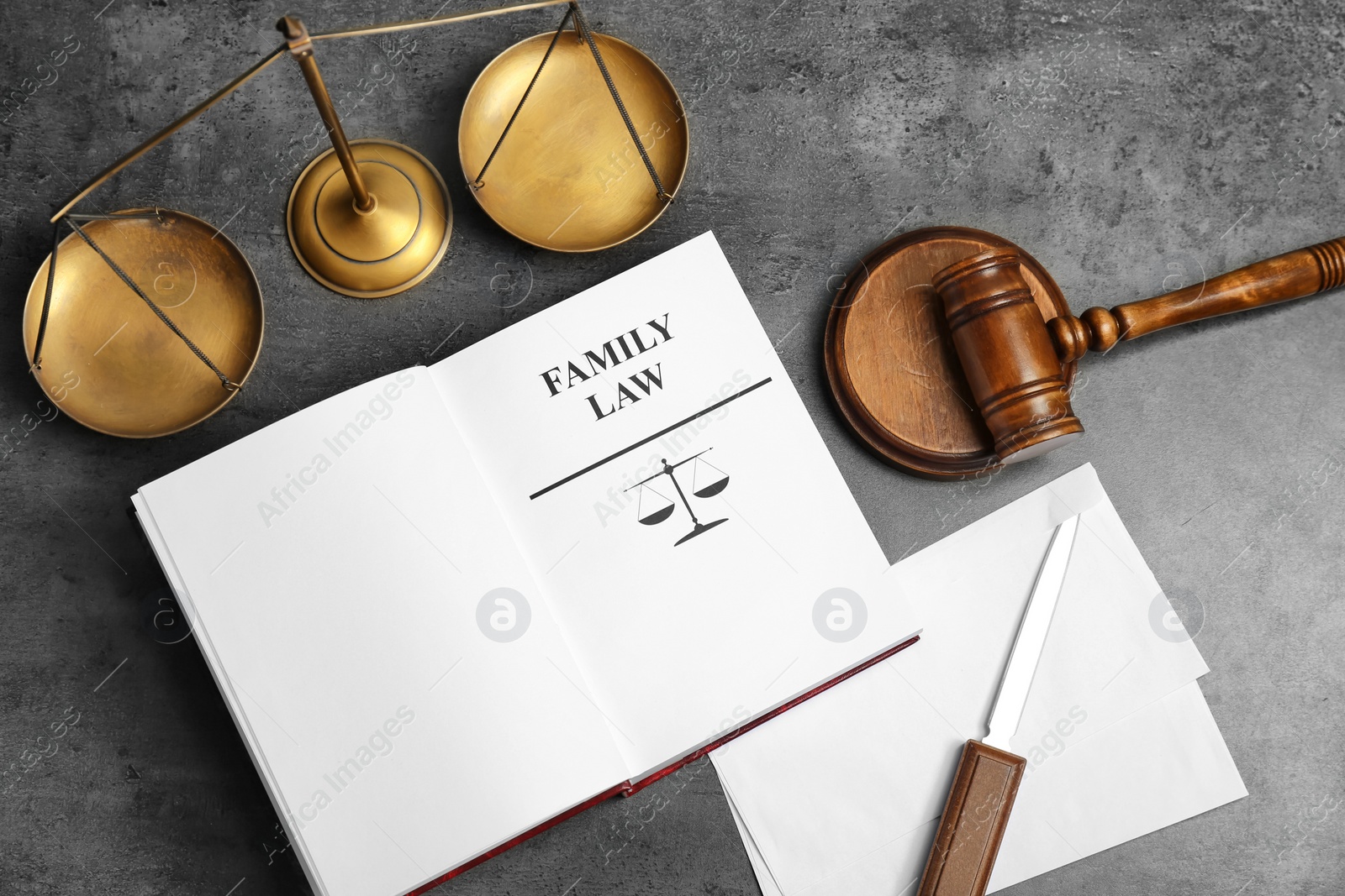 Photo of Flat lay composition with book, gavel and scales of justice on grey background. Family law concept