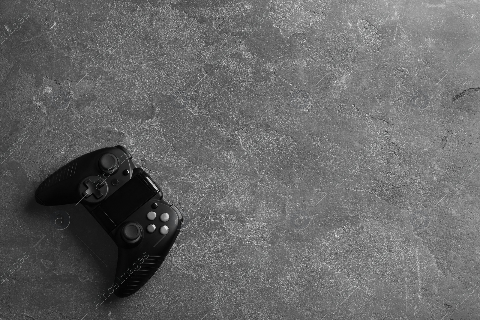 Photo of Modern video game controller on grey background, top view with space for text