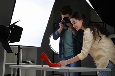 Photo of Professional photographers shooting stylish shoes in studio