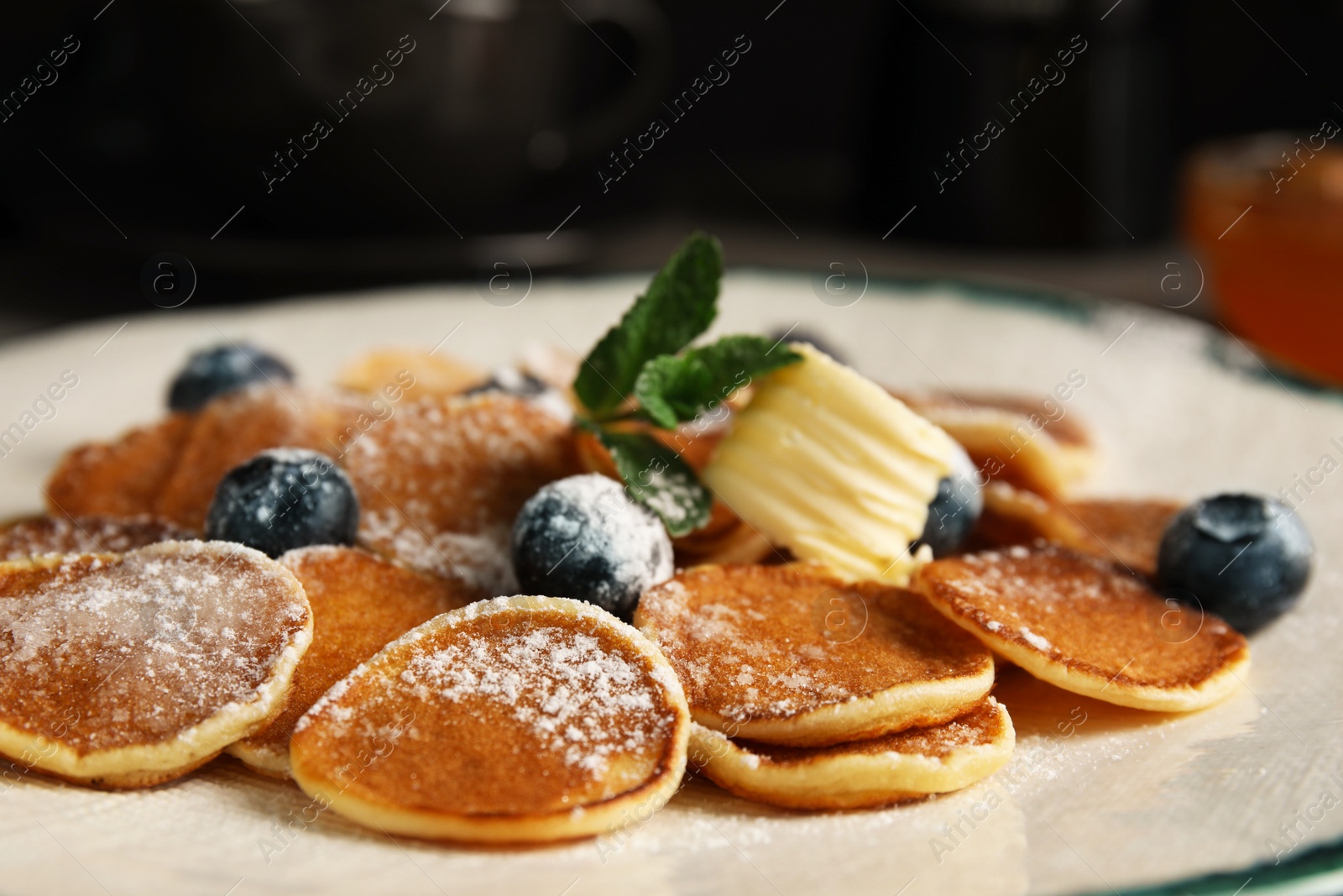 Photo of Cereal pancakes with blueberries and butter on plate, closeup