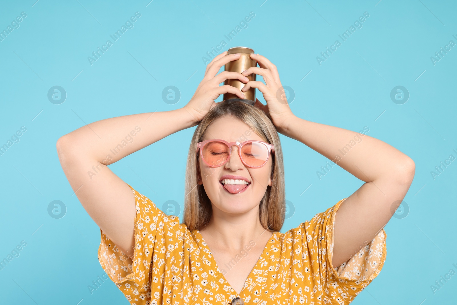 Photo of Beautiful happy woman holding beverage can against light blue background