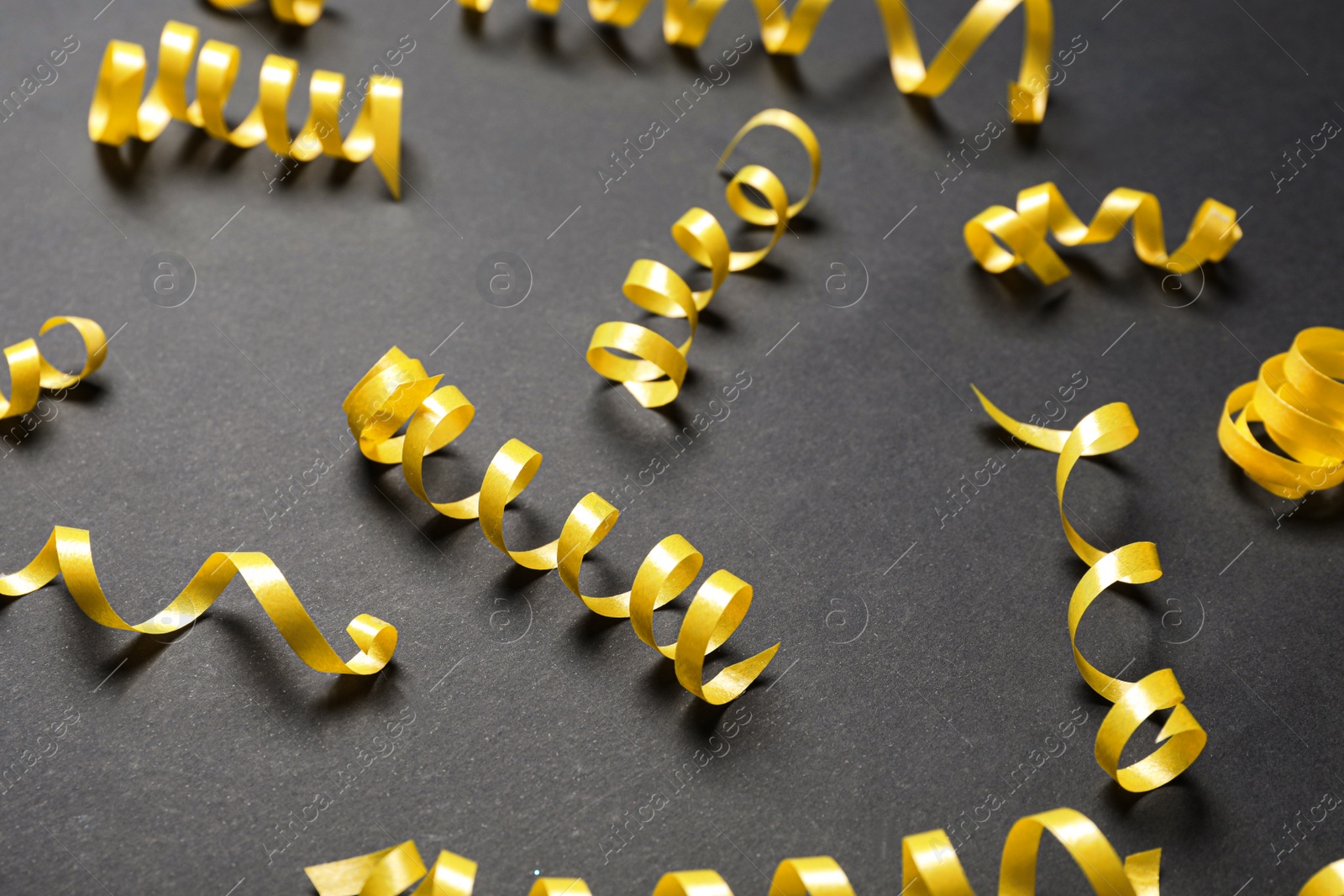 Photo of Many yellow serpentine streamers on black background