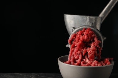 Photo of Metal meat grinder with beef mince on black background. Space for text