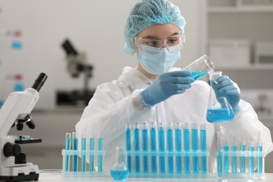 Photo of Scientist pouring sample into flask in laboratory