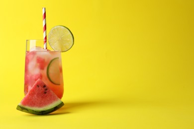 Tasty summer watermelon drink with lime in glass on yellow background. Space for text