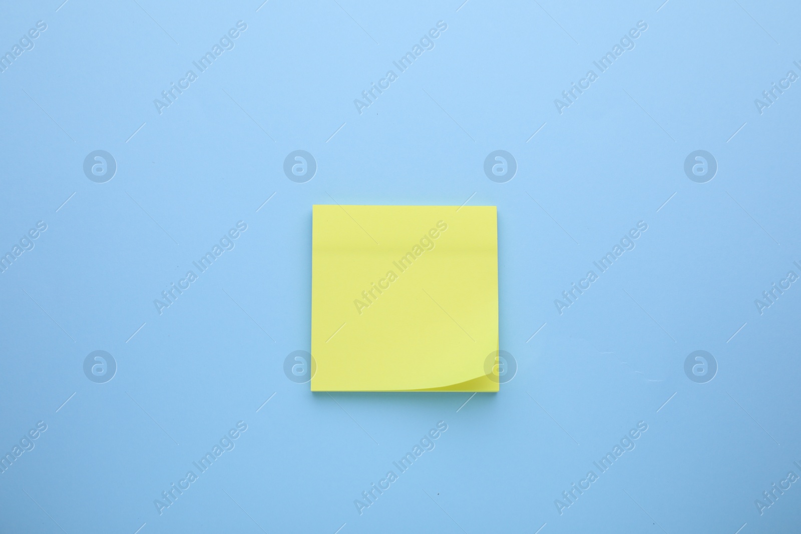 Photo of Paper note on light blue background, top view