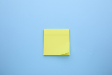 Photo of Paper note on light blue background, top view