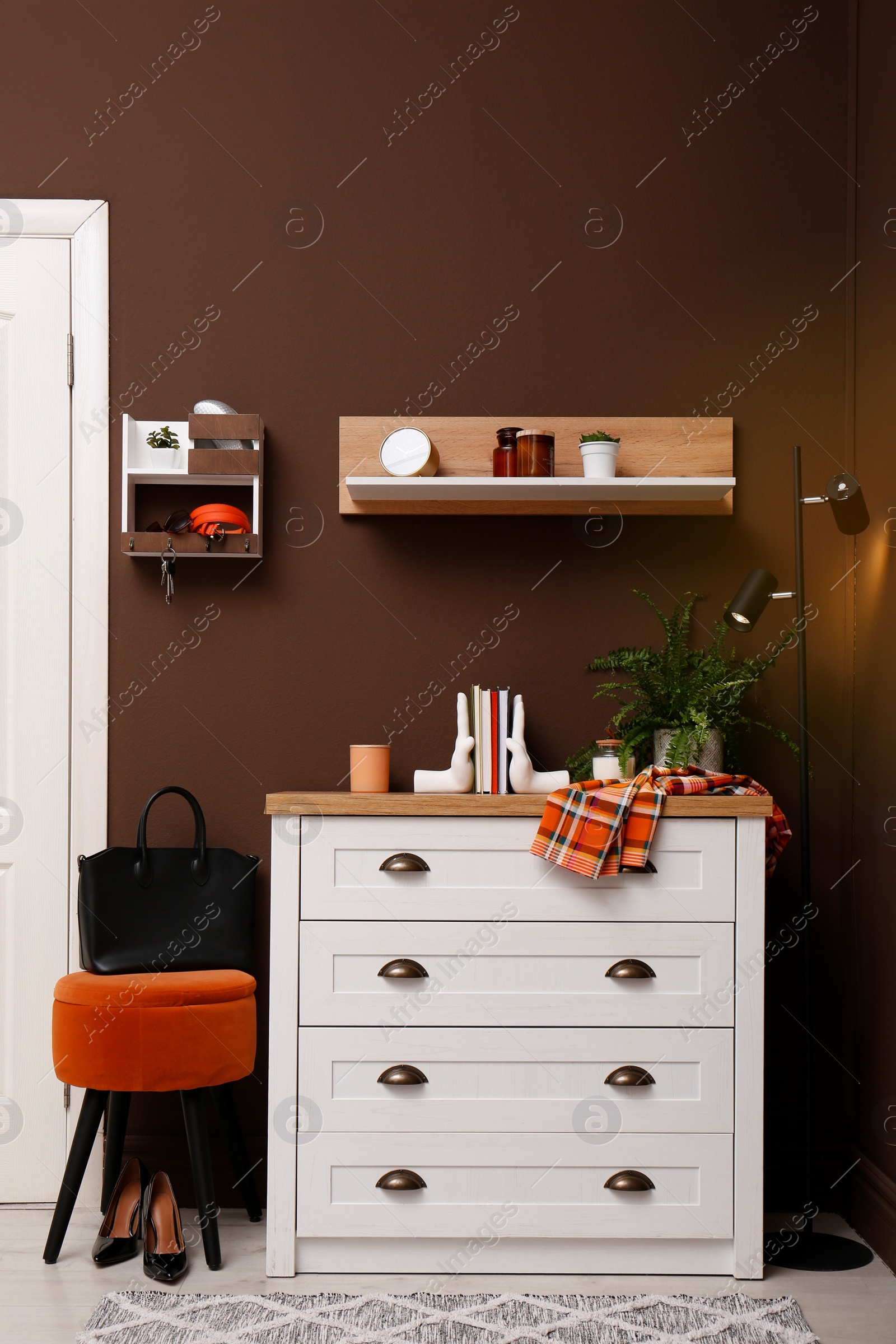 Photo of Stylish hanger for keys on brown wall in hallway