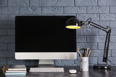 Photo of Computer with blank monitor on office table. Mock up for design