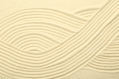 Photo of Zen rock garden. Wave pattern on beige sand, top view